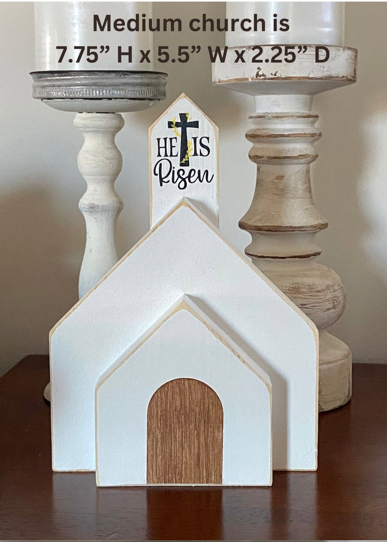 May include: A white wooden church with a brown wooden door and the text "He is Risen" on the front. The church is 7.75 inches tall, 5.5 inches wide, and 2.25 inches deep.