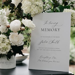 May include: A white sign with black text reads "In loving memory of the mother of the bride, Julia Smith. You may not be with us today, but you are always in our hearts. Everything I am, I am because you love me."