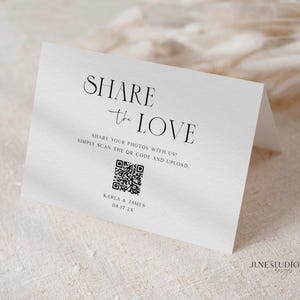 May include: A white folded card with the words "SHARE the LOVE" in elegant black script. Below, it reads "SHARE YOUR PHOTOS WITH US! SIMPLY SCAN THE QR CODE AND UPLOAD." Includes a QR code, names "KARLA & JAMES" and date "08.17.2X".