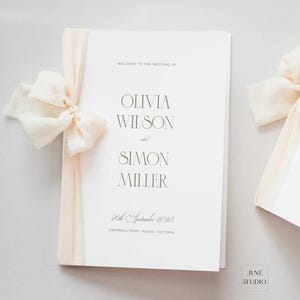 Könnte beinhalten: Ein Hochzeitsprogramm mit den Namen Olivia Wilson und Simon Miller in eleganter Schrift. Das Programm ist mit einem cremefarbenen Band gebunden und enthält das Datum 20. September 2025 und den Veranstaltungsort. Das June Studio-Logo befindet sich unten rechts.