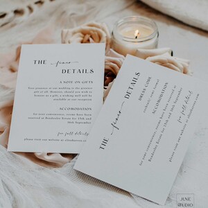 Peut inclure: Deux cartes blanches avec du texte noir d&eacute;taillant les informations du mariage. Les cartes sont intitul&eacute;es "The finer details" et comprennent des informations sur les cadeaux, l'h&eacute;bergement et le code vestimentaire. Les cartes sont sur une surface blanche avec une bougie et des fleurs.