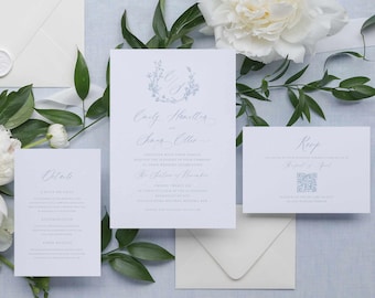 Puede incluir: Un juego de invitaciones de boda blancas con monogramas de coronas florales en azul claro y texto en caligrafía elegante. El set incluye una invitación principal, una tarjeta RSVP con código QR, una tarjeta de detalles y un sobre blanco.