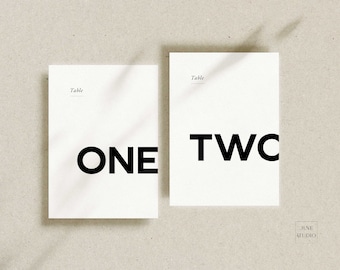 May include: Two white cards with black text. The first card says "Table One" and the second card says "Table Two".