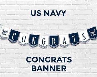 May include: A white and blue banner with the words "CONGRATS" in navy blue letters. The banner is decorated with small navy blue flags with a white star and the US Navy emblem. The banner is hanging on a white brick wall. The text "US NAVY CONGRATS BANNER" is below the banner.