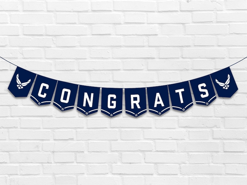 May include: A navy blue banner with white letters spelling "CONGRATS" and a white Air Force logo on each end.