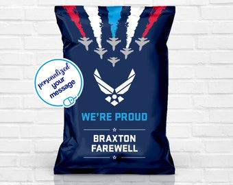 May include: Navy blue gift bag with a design featuring fighter jets and the text "WE'RE PROUD". The bag includes the Air Force emblem and space for a personalized message. The bag's design includes red, white, and blue accents.
