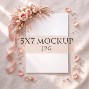 Op de afbeelding: Een 5x7 mockup met de tekst "5X7 MOCKUP JPG" is versierd met roze rozen, gedroogde bloemen en een vloeiend roze lint. Verspreide roze bloemblaadjes en takjes gipskruid dragen bij aan de zachte, romantische uitstraling. De achtergrond is een textiel met lichte kleur.