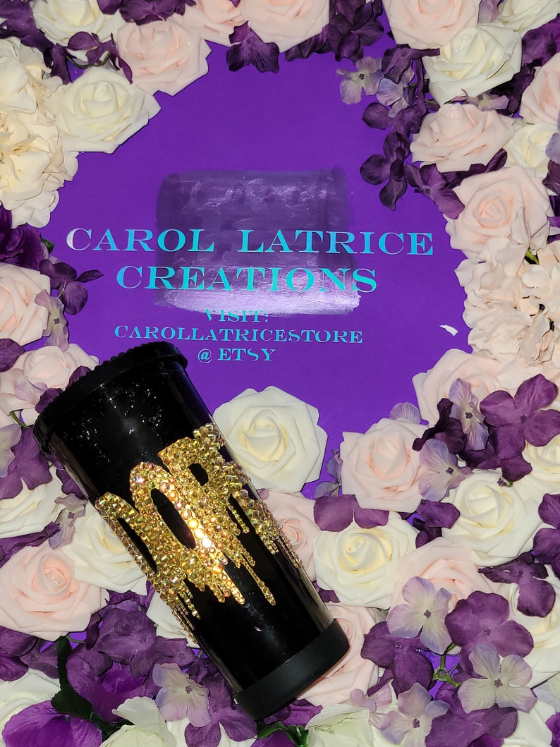 May include: Black tumbler with a gold glitter design that says "30" with gold glitter dripping down the side. The tumbler is surrounded by white and purple flowers.