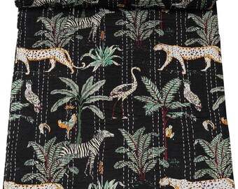 Puede incluir: Colcha de algodón negro con un patrón repetido de cebras, leopardos, flamencos y palmeras. La colcha está acolchada con hilo blanco.