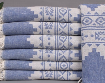May include: A stack of blue and white patterned Turkish towels. The towels have a geometric design and fringed edges. The towels are made of a soft, absorbent material, perfect for use in a bathroom or at the beach.