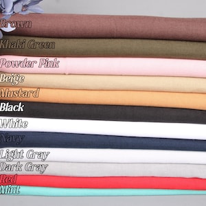 May include: A stack of 12 scarves in various colors, including brown, khaki green, powder pink, beige, mustard, black, white, navy, light gray, dark gray, red, and mint.
