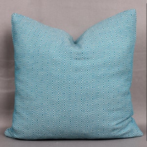 May include: A teal blue throw pillow with a white diamond pattern.