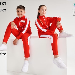 May include: Two children wearing red and white tracksuits with white stripes down the sides. The children are sitting on a white platform. The text "LOGO / TEXT EMBROIDERY" is at the top of the image. The text "Red/White" is at the bottom of the image.