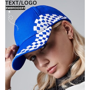 Puede incluir: Una gorra de béisbol azul con un patrón de cuadros blancos alrededor del borde. La gorra tiene una visera curvada y una corona estructurada.