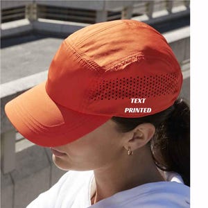 May include: Orange baseball cap with a mesh panel and a white "TEXT PRINTED" logo.