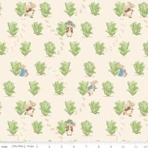 May include: A cream-colored fabric featuring a repeating pattern of light brown rabbits and green lettuce heads. The rabbits are depicted in various poses, some wearing blue jackets, interspersed with small brown paw prints across the surface.