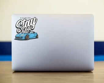 May include: A blue car with the words "Stay Low" in white lettering on a white laptop.