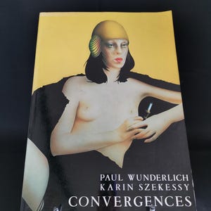May include: A book cover featuring a woman with a yellow hat and black hair. The title "CONVERGENCES" is displayed in white text, with the authors' names, Paul Wunderlich and Karin Szekessy, above it. The background is yellow and black.