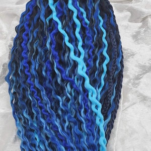 Mixture of light blue, medium blue and dark blue curly extensions with braids.