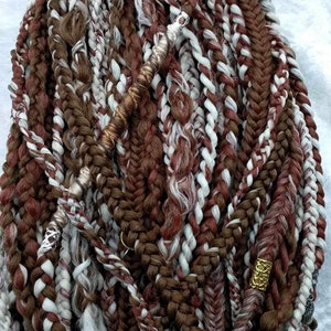 May include: A close-up of a set of brown, white, and burgundy synthetic hair extensions with gold and silver beads. The extensions are braided and twisted together.