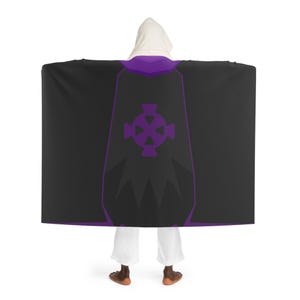 May include: A hooded cloak in black with purple trim and a purple Celtic cross design on the back. The hood is white. The cloak is worn by a person wearing white pants and brown shoes.