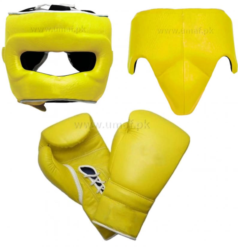 May include: A set of yellow boxing equipment, including a head guard, groin protector, and a pair of boxing gloves. The equipment is made of leather and has a white trim.