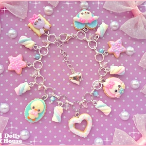 May include: A silver charm bracelet featuring a selection of adorable charms, including a heart, a star, a marshmallow, and a penguin. The charms are all crafted from polymer clay and painted in pastel shades. This bracelet is ideal for adding a touch of whimsy to any outfit.