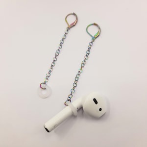 May include: A pair of iridescent chain ear hooks with a white silicone earbud attached to one of the chains.