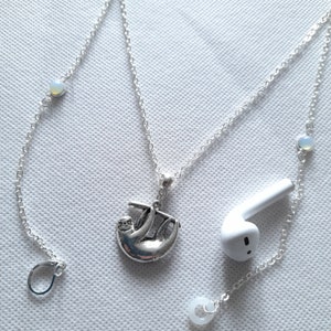 May include: Silver chain necklace with a sloth charm and opal beads. The necklace is designed to hold earphones.