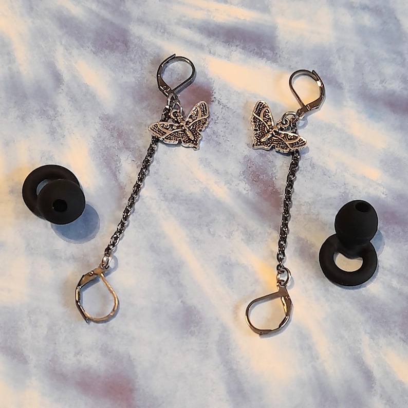 May include: A white ceramic mug with a black handle and the text "But First, Coffee" in a handwritten style. The mug is on a white surface. The mug is 4 inches tall.