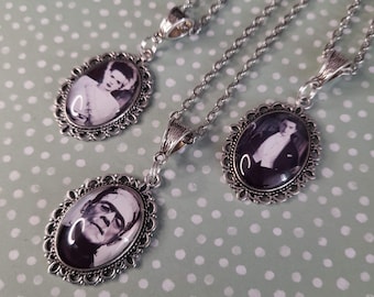 May include: Three silver necklaces with oval-shaped pendants featuring black and white images of classic horror movie characters. The pendants have a decorative filigree border.
