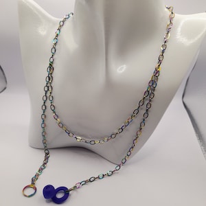 May include: A rainbow-colored chain necklace with a purple silicone earplug charm. The chain is made of metal and has a delicate, oval-link design.