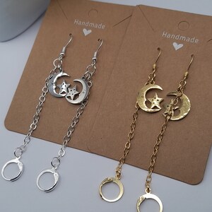 Könnte beinhalten: Zwei Paar handgefertigte Ohrringe mit einem Halbmond- und Stern-Anhänger. Ein Paar ist silber mit einer silbernen Kette und das andere ist gold mit einer goldenen Kette.