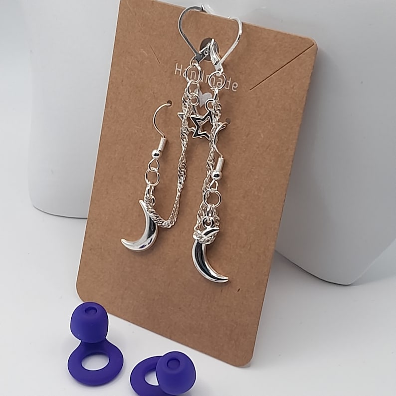This image shows the moon and stars loop earplug earrings displayed on a brown craft card backing with a pair of loop earplugs on the surface below.