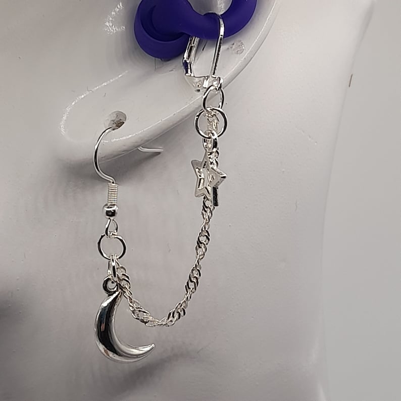 This image shows the moon and star loop earplug earrings being worn with the loop earplug in the ear and showing the drape of the chain.