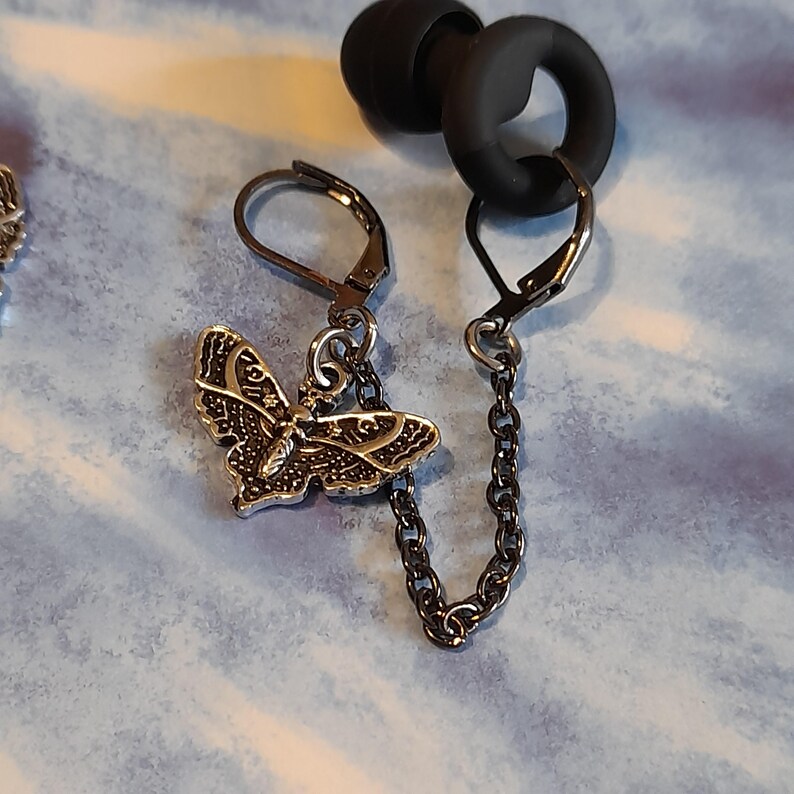 May include: A white ceramic mug with a black handle and the text "But first, coffee" in a black, handwritten-style font. The mug is on a white surface.