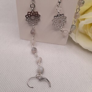 May include: Silver earrings with a delicate mandala design and a chain of white agate beads.