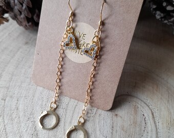May include: Gold earrings with a dangling chain and a heart charm with clear rhinestones. The earrings are on a brown card with the text "Handmade" and "Live, Love, Create" on it.