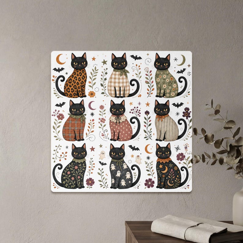 Nine black cats with decorative outfits and Halloween motifs on a white background.