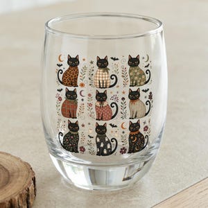 Glass tumbler with nine different illustrated black cats and Halloween motifs.