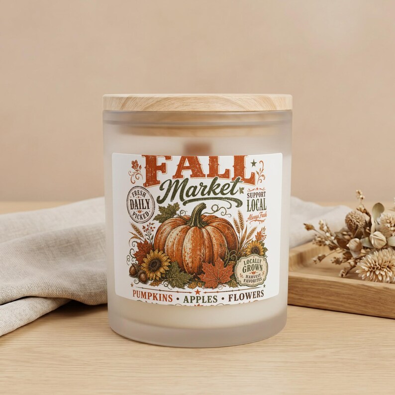 Frosted glass candle with wooden lid, featuring Fall Market label with pumpkin and autumn motifs.