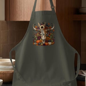 Gray apron with a bull skull adorned with flowers, pumpkins, and bats.