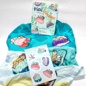 May include: A children's book titled Pūpū Hinuhinu A Hawaiian Lullaby, a teal and white patterned fabric swaddle featuring illustrations of babies sleeping on shells, and a sticker sheet with five individual shell and baby illustrations.