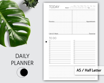 May include: A black and white daily planner with a gridded section for appointments, a to-do list, and a section for calls and emails. The planner is labeled "TODAY" and "DAILY PLANNER".