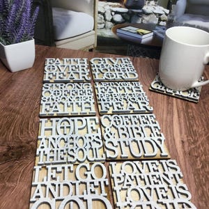 May include: Set of six wooden coasters with inspirational quotes in white lettering. The quotes include "Faith over fear", "Give thanks to the Lord", "Strong coffee stronger faith", "Hope anchors the soul", "Coffee & Bible study", and "Love is patient, love is kind".