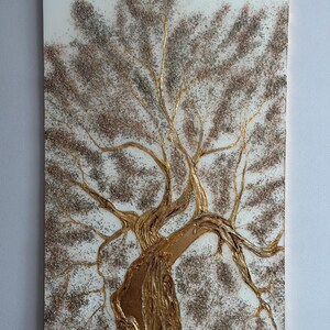 May include: A rectangular wall art piece featuring a textured, metallic gold tree trunk and branches set against a white background. The tree canopy is filled with dense, sparkling bronze and silver glitter, creating a shimmering, dimensional effect.