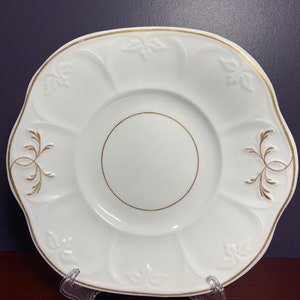 Vintage White Cake Plate with Gold Trim.   Leaves are embossed in white within panels around the outside of the plate.