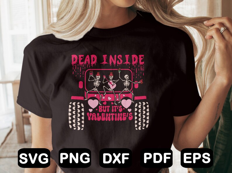 May include: A black t-shirt with a graphic of three skeletons in a pink jeep. The skeletons are holding musical instruments and the text "Dead Inside - But It's Valentine's" is printed below the jeep.