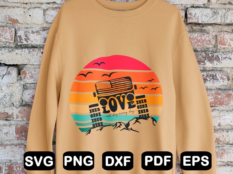 May include: A tan sweatshirt featuring a graphic design of a jeep driving through a sunset with the words "XOXO LOVE XOXO all day every day XOXO XOXO XOXO" printed on it.