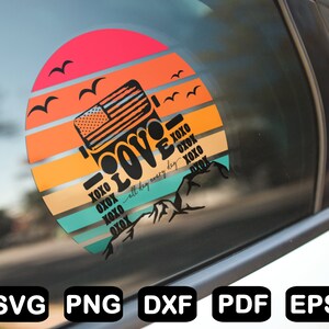 May include: A round sticker featuring a sunset backdrop and a silhouette of a Jeep with the word "LOVE" in a retro typeface. The text "all day every day" is written beneath the Jeep. The sticker is displayed on a car window.